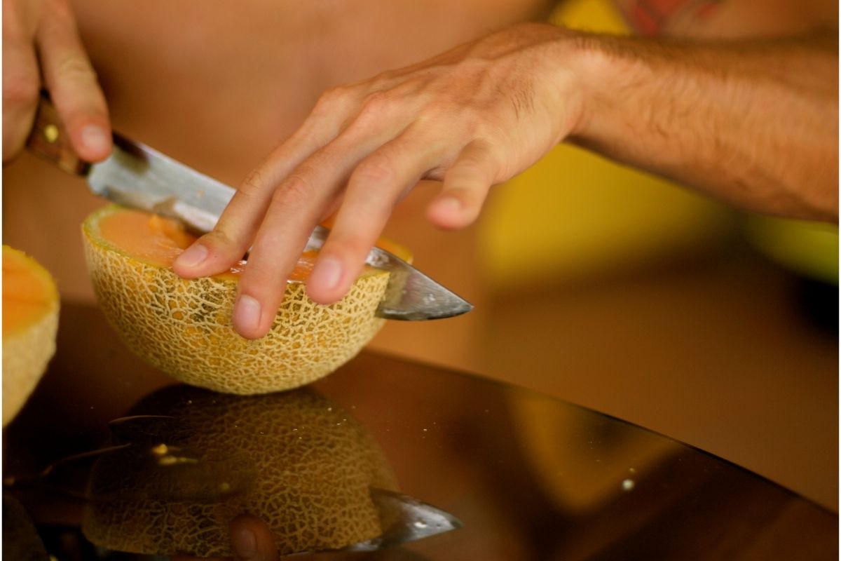 Man cuts fresh cantaloupe